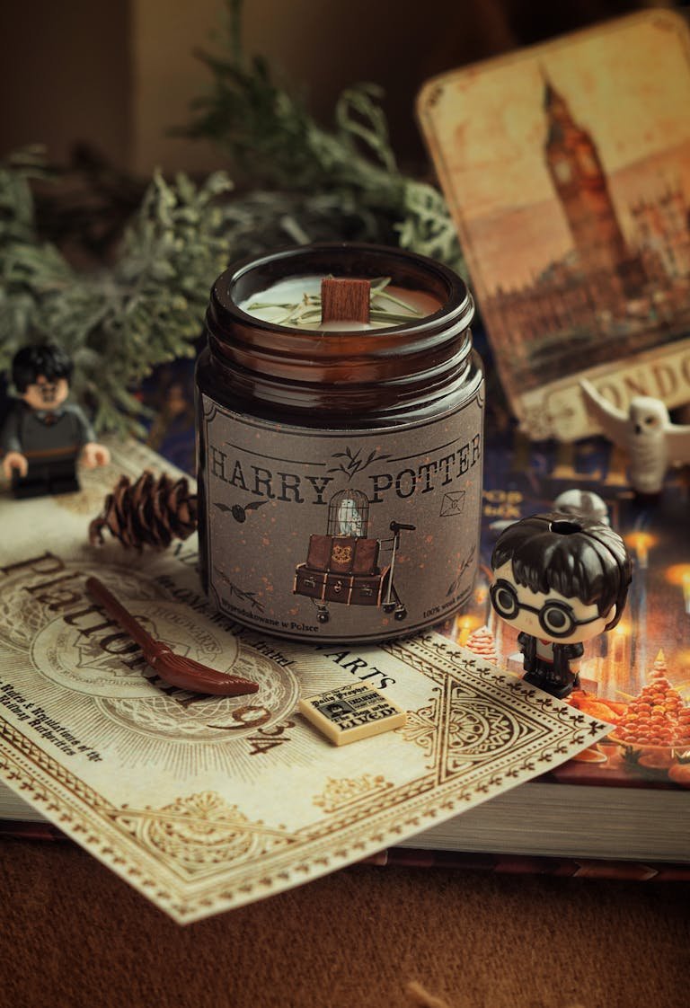 A warm Harry Potter inspired scene with candle, figurines, and magical props, perfect for cozy decor.