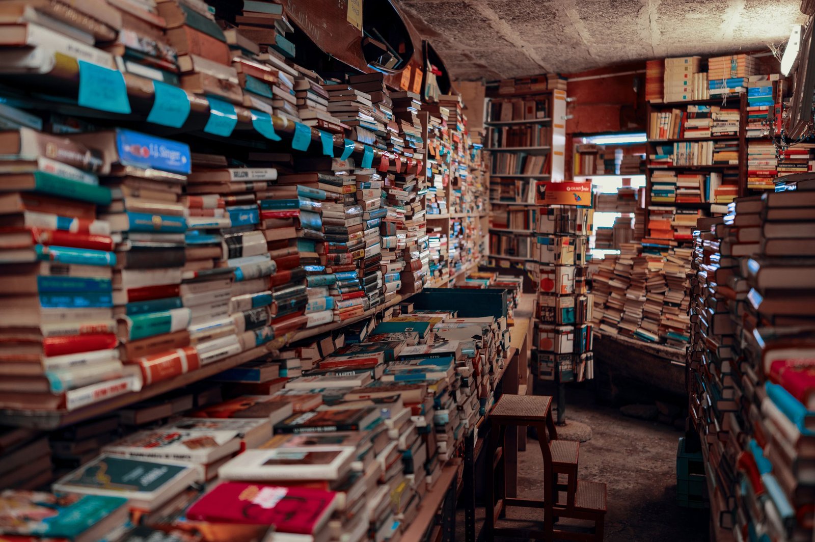 Hidden Bookshops in London -An inviting bookstore interior filled with stacks of diverse books on shelves, creating a warm ambiance.