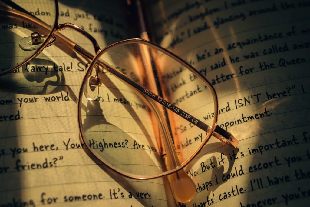 Dialogue Journal Example - Vintage round spectacles rest on an open journal with handwritten notes.